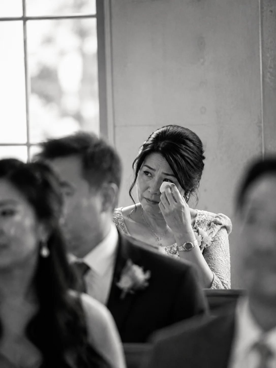 A parent wipes away a tear during a wedding ceremony
